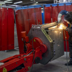 Employee welding with the help of a robot
