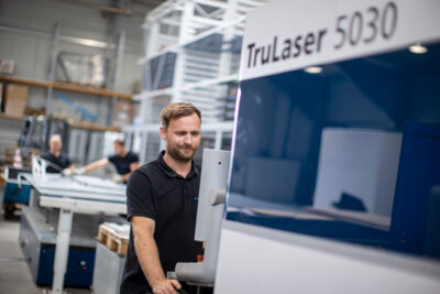 Mitarbeiter bedient eine Lasermaschine zur Blechbearbeitung